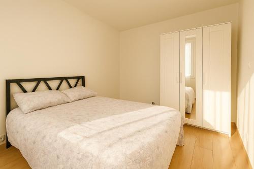 une chambre blanche avec un lit et une fenêtre dans l'établissement appartement 3 chambres avec balcon et parking, à Montpellier