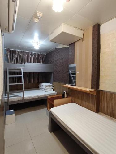 a room with two bunk beds and a kitchen at New Mong Kok Guest House in Hong Kong