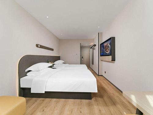 a bedroom with a large white bed in a room at Jinjiang Inn Changchun Xi An Avenue Branch in Changchun