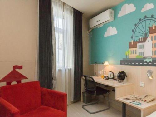 a room with a red chair and a desk with a computer at Jinjiang Inn Changchun Xi An Avenue Branch in Changchun