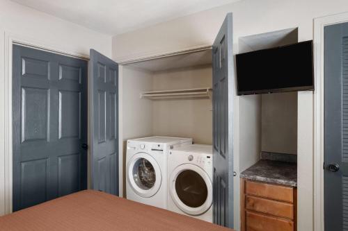 a laundry room with a washer and dryer at Eagle's Den Suites Big Spring a Travelodge by Wyndham in Big Spring