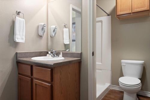 a bathroom with a sink and a toilet at Eagle's Den Suites Carrizo Springs a Travelodge by Wyndham in Carrizo Springs