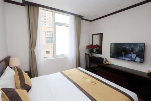 a hotel room with a bed and a television at Lenid Hotel Tho Nhuom in Hanoi