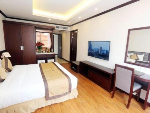 a bedroom with a bed and a desk and a computer at Lenid Hotel Tho Nhuom in Hanoi