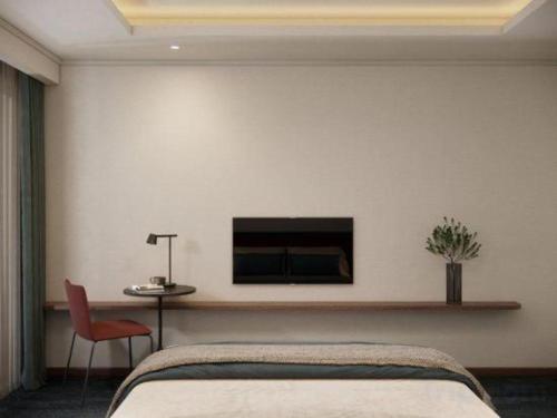 a bedroom with a bed and a tv on the wall at Lenid Hotel Tho Nhuom in Hanoi