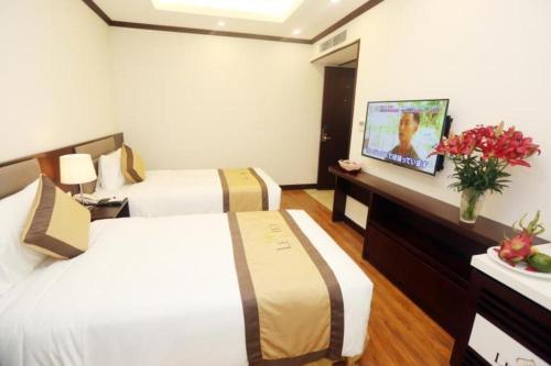 a hotel room with two beds and a television at Lenid Hotel Tho Nhuom in Hanoi