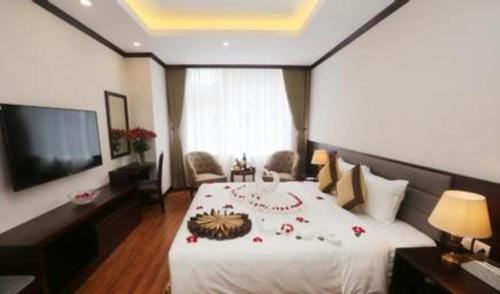 a bedroom with a large white bed and a television at Lenid Hotel Tho Nhuom in Hanoi
