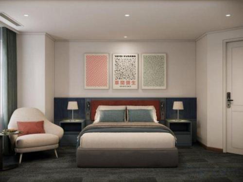 a bedroom with a bed and a chair at Lenid Hotel Tho Nhuom in Hanoi