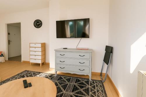 Cette chambre comprend une commode et une télévision murale. dans l'établissement appartement 3 chambres avec balcon et parking, à Montpellier