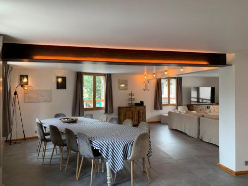 une salle à manger avec une table, des chaises et un canapé dans l'établissement Maison capsule, au Monêtier-les-Bains
