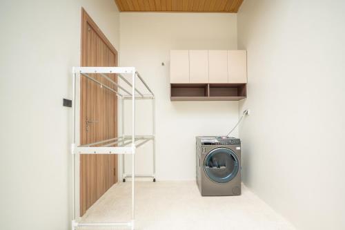 a washing machine in a room with a door at Mouana Residence Song Khun Chalong 5-bedroom Pool Villa 89-11 in Chalong 