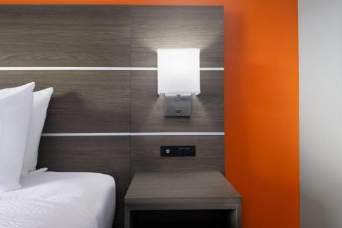 a room with a bed and a lamp on a wall at Baymont by Wyndham Salisbury MD in Salisbury