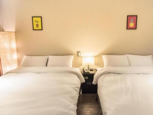 two beds sitting next to each other in a room at Check Inn Hotel in Jeju