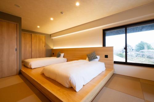 Una cama o camas en una habitación de 奥州平泉温泉旅館 itsumu