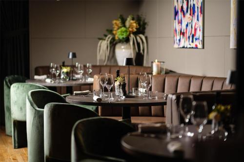 a restaurant with tables and chairs with wine glasses at Hyatt Place Gothenburg Central in Gothenburg