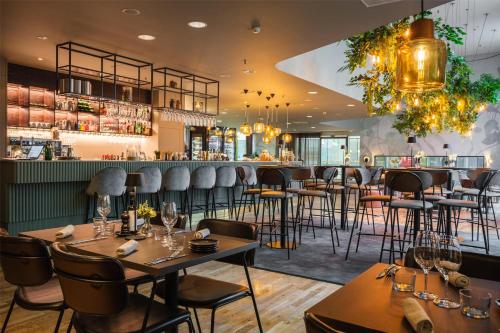 a restaurant with tables and chairs and a bar at Hyatt Place Gothenburg Central in Gothenburg