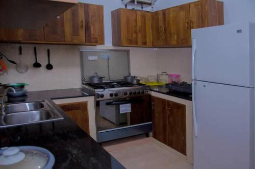 a kitchen with a stove and a sink and a refrigerator at New King well resort and guest house in Ahangama