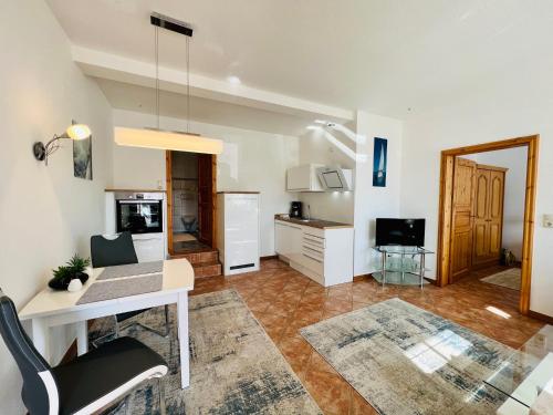 a living room with a desk and a kitchen at Lexow - Hotel an de Havenkant in Tönning
