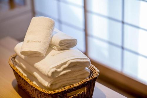 a basket filled with white towels on a table at RESI STAY Kumico Amaterrace in Kyoto