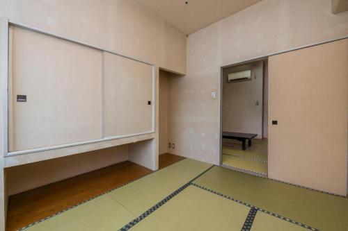 an empty room with a large door and a mirror at Hotel Alphastar Iwappara in Yuzawa