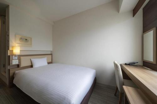 a bedroom with a bed and a desk and a bed sidx sidx sidx at Hotel Oriental Express Nagoya Sakae in Nagoya