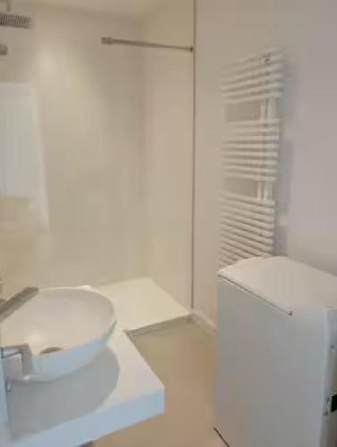 une salle de bain blanche avec un lavabo et des toilettes dans l'établissement Studio 150 m de la plage, à Bénodet