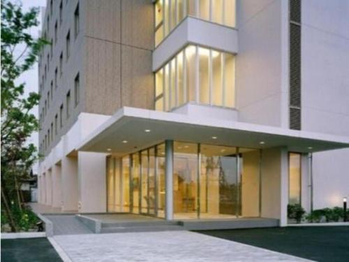 a large building with glass doors and windows at Hirata Maple Hotel in Izumo