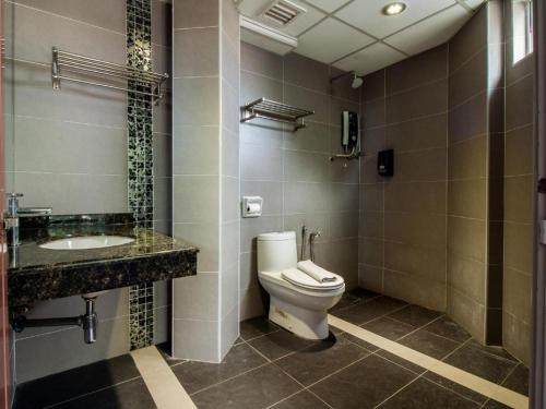 a bathroom with a toilet and a sink at e Hotel in Melaka