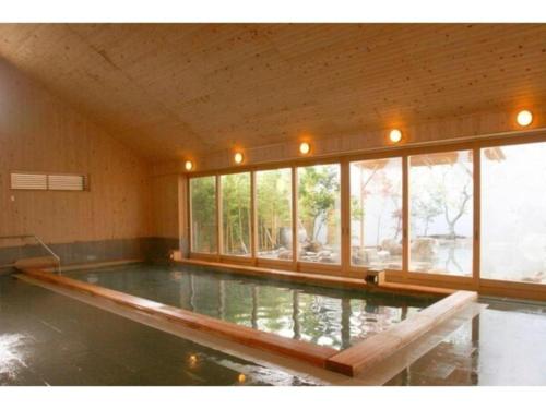 a swimming pool in a room with windows at Hirata Maple Hotel in Izumo