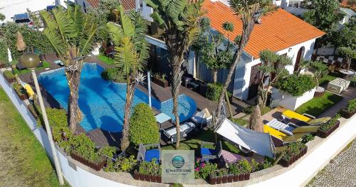 an overhead view of a house with a swimming pool and palm trees at RUMAH Esposende in Esposende