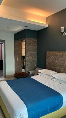 a bedroom with a large bed with a blue blanket at In Trend Hotel in Cukai