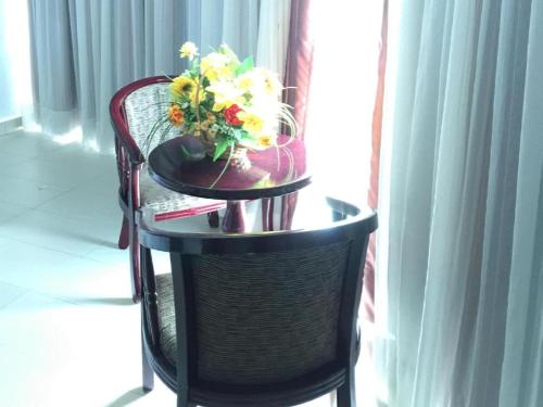 a table with a vase of flowers on top of it at Loong Fatt Hotel in Sungkai