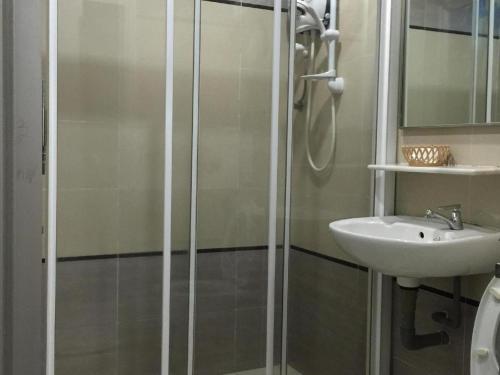 a bathroom with a shower and a sink at Loong Fatt Hotel in Sungkai