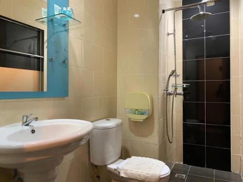 a bathroom with a sink and a toilet and a shower at Disini Hotel in Kampong Sembulan