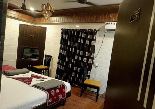 a room with a bed and two chairs in it at Hotel Geetanjali St Bus Stand Panvel in Panvel
