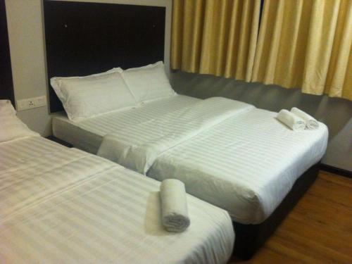 two beds in a hotel room with towels on them at Portview Hotel in Klang