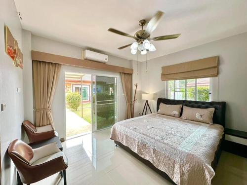 ein Schlafzimmer mit einem Bett und einem Deckenventilator in der Unterkunft Luxury 6BHK Villa with Private Pool in Pattaya by - OzyStays in Nong Prue