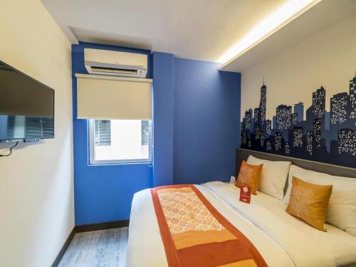 a bedroom with a blue wall and a bed at OYO 264 City Edge Hotel in Kuala Lumpur