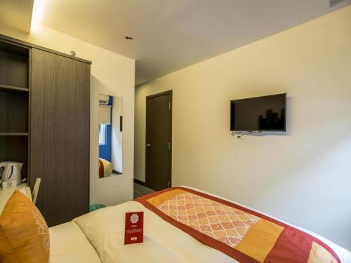 a bedroom with a bed and a tv on the wall at OYO 264 City Edge Hotel in Kuala Lumpur