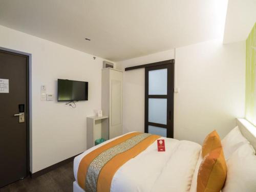 a bedroom with a bed and a flat screen tv at OYO 264 City Edge Hotel in Kuala Lumpur