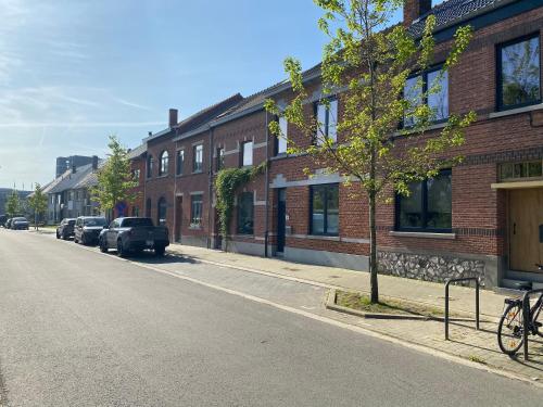 a street with cars parked next to a brick building at Maison Magnifiek in Hasselt