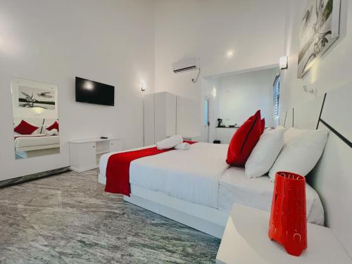 a bedroom with a white bed with red pillows at WetLand Resort in Negombo