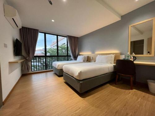 ジョホールバルにあるMIYABI HOTEL PERMASのベッドが2つと窓があるホテルの部屋