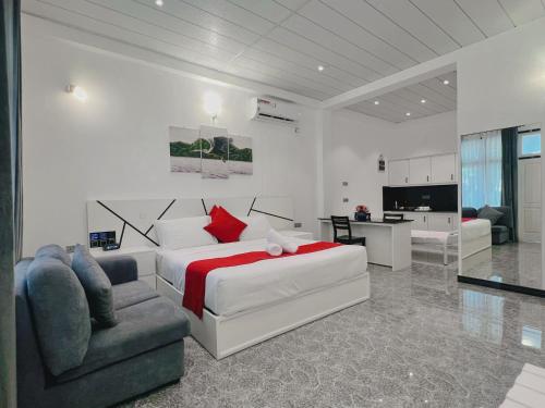a bedroom with a bed and a couch and a chair at WetLand Resort in Negombo