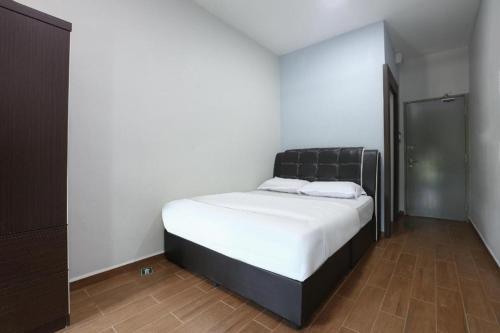 a bedroom with a large bed with a black headboard at OYO 89859 PP Traveller's Hotel in Pasir Puteh