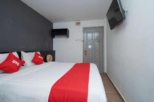 a bedroom with a large bed with red and white pillows at OYO 90106 Sindbad Hotel in Kuala Lumpur