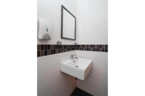 a white bathroom with a sink and a mirror at OYO 90106 Sindbad Hotel in Kuala Lumpur