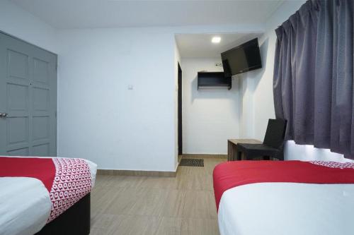 a hotel room with two beds and a television at OYO 90106 Sindbad Hotel in Kuala Lumpur