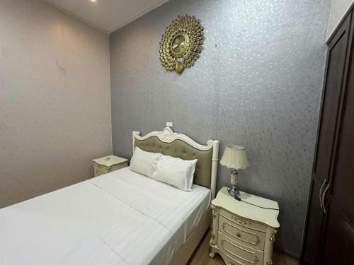 a bedroom with a white bed and two night stands at Hanoi 0riental Hotel & Travel in Hanoi
