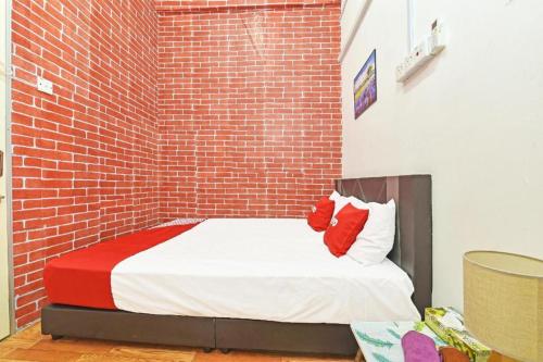 a bed in a room with a brick wall at OYO 90431 CZ Hotel in Pasir Puteh
